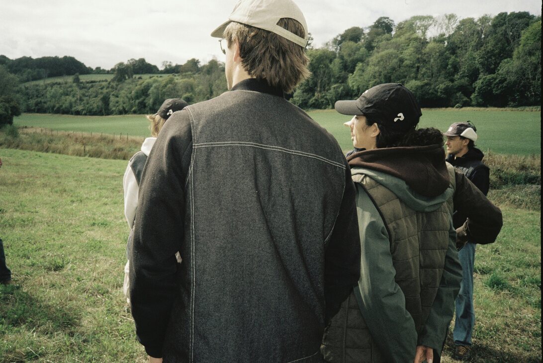 A group walking through farmland wearing Ponda gilets and caps